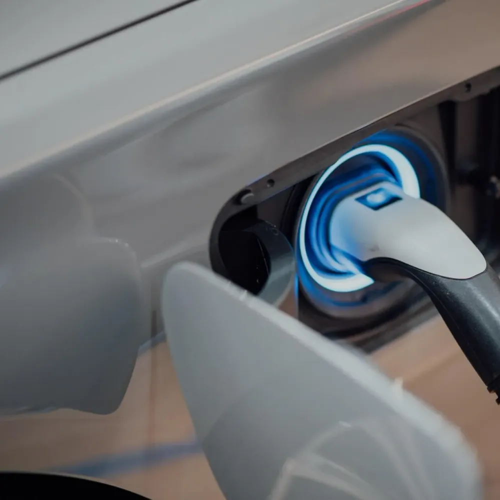 Close-up of an EV charging connector plugged into a vehicle